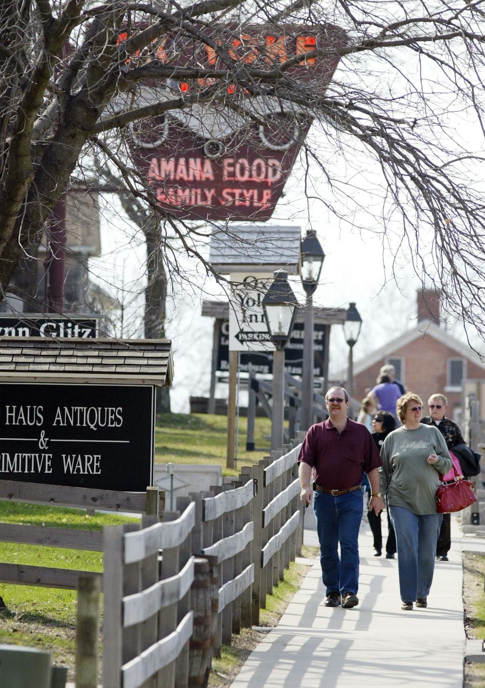 Tourists walk past restaurants and shops in the historic Germanic town of Amana.