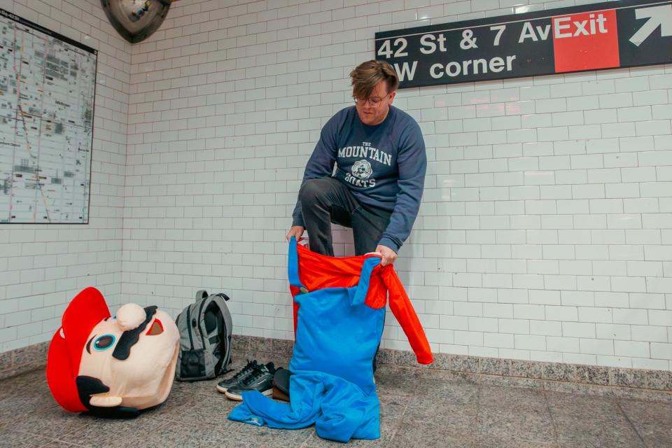 Luke steps inside the Mario costume in a subway station.