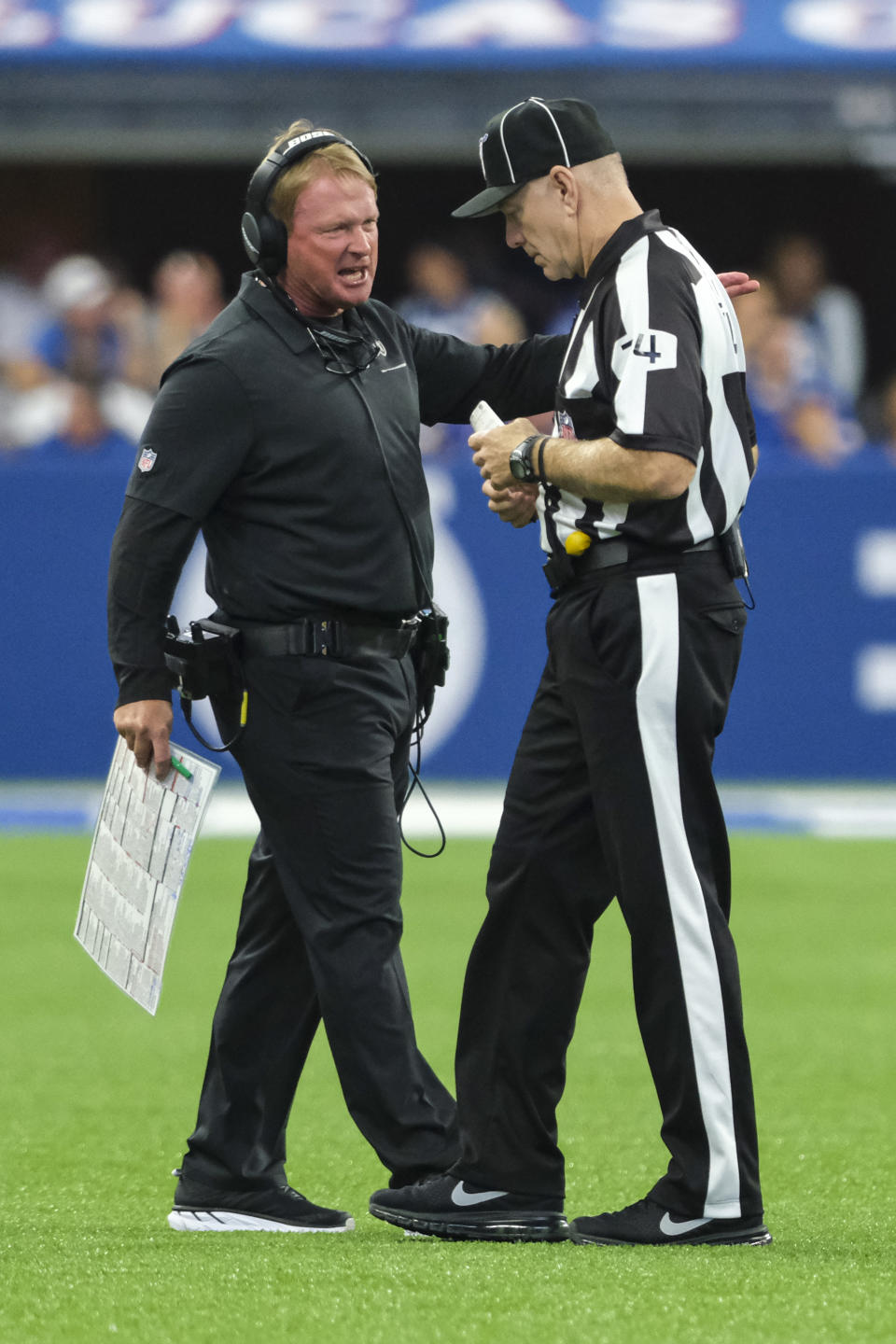 Oakland Raiders head coach Jon Gruden talks with head linesman Derick Bowers (74) during the first half of an NFL football game against the Indianapolis Colts in Indianapolis, Sunday, Sept. 29, 2019. (AP Photo/AJ Mast)