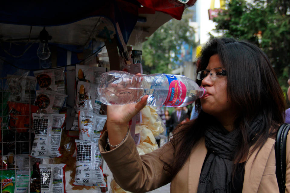 In this Jan. 9, 2014 photo, a woman drinks bottled water in Mexico City. Bad tap water accounts in part for Mexico being the highest consumer of bottled water and sweetened drinks. A law recently approved by Mexico City’s legislators will require all restaurants to install filters, offering patrons free, apparently drinkable potable water that won’t lead to stomach problems and other ailments. With an obesity epidemic looming nationwide, the city’s health department decided to back the water initiative. (AP Photo/Marco Ugarte)