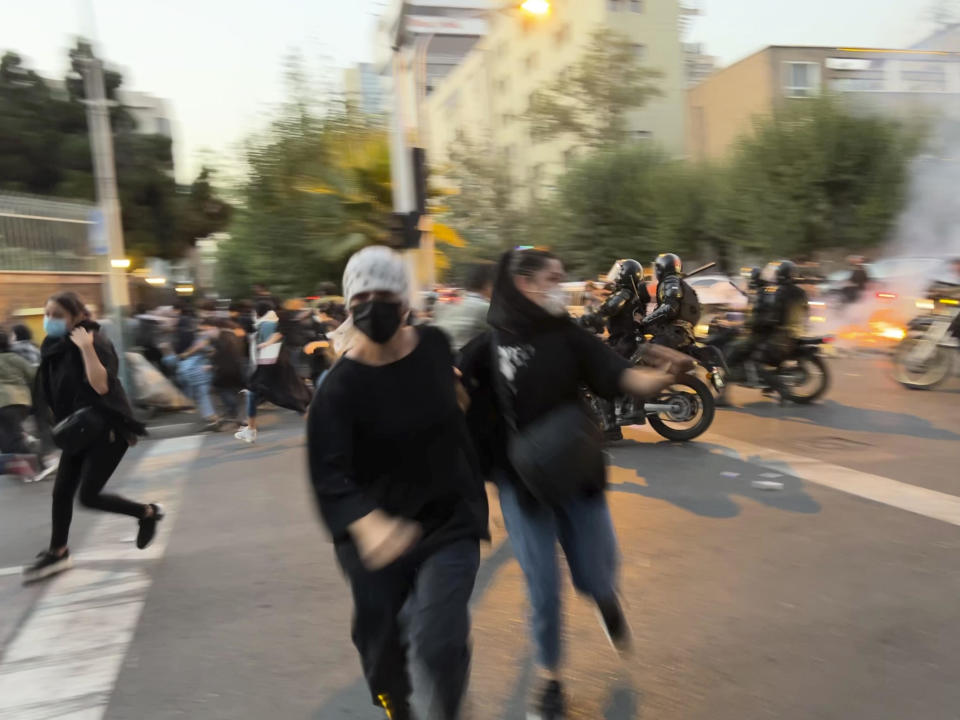In this Sept. 19, 2022 photo, taken by an individual not employed by The Associated Press and obtained by the AP outside Iran, women run away from anti-riot police during a protest over the death of a young woman detained for violating the country's conservative dress code, in downtown Tehran, Iran. / Credit: AP
