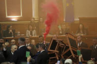 A democratic lawmaker holds a flare during a parliament session, in Tirana, Albania, Monday, Nov. 20, 2023. Albanian opposition lawmakers disrupted the Parliament's session again on Monday to protest against what they say, is increasingly authoritarian rule by the governing Socialists. (AP Photo/Florian Abazi)