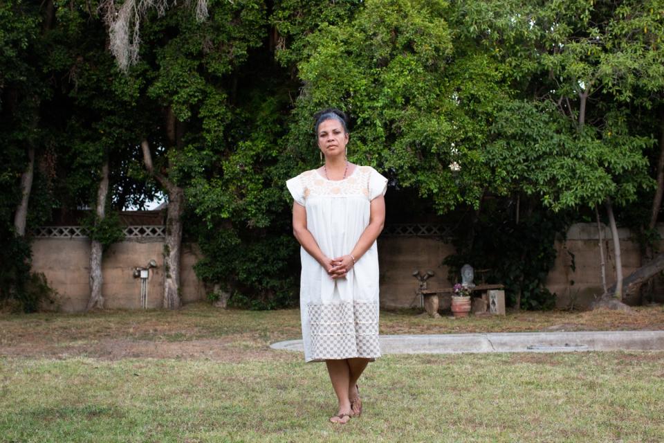 Melina Abdullah stands for a portrait in her Mid-City backyard