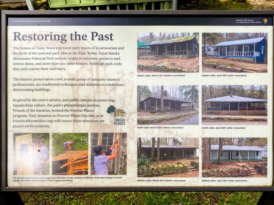 An informative sign shows text titled "Restoring the Past" with photos of cabins on the right