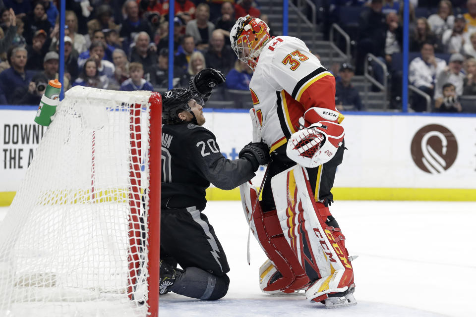 Calgary Flames goaltender David Rittich (33) knocks down Tampa Bay Lightning center Blake Coleman (20) after the two collided during the second period of an NHL hockey game Saturday, Feb. 29, 2020, in Tampa, Fla. (AP Photo/Chris O'Meara)