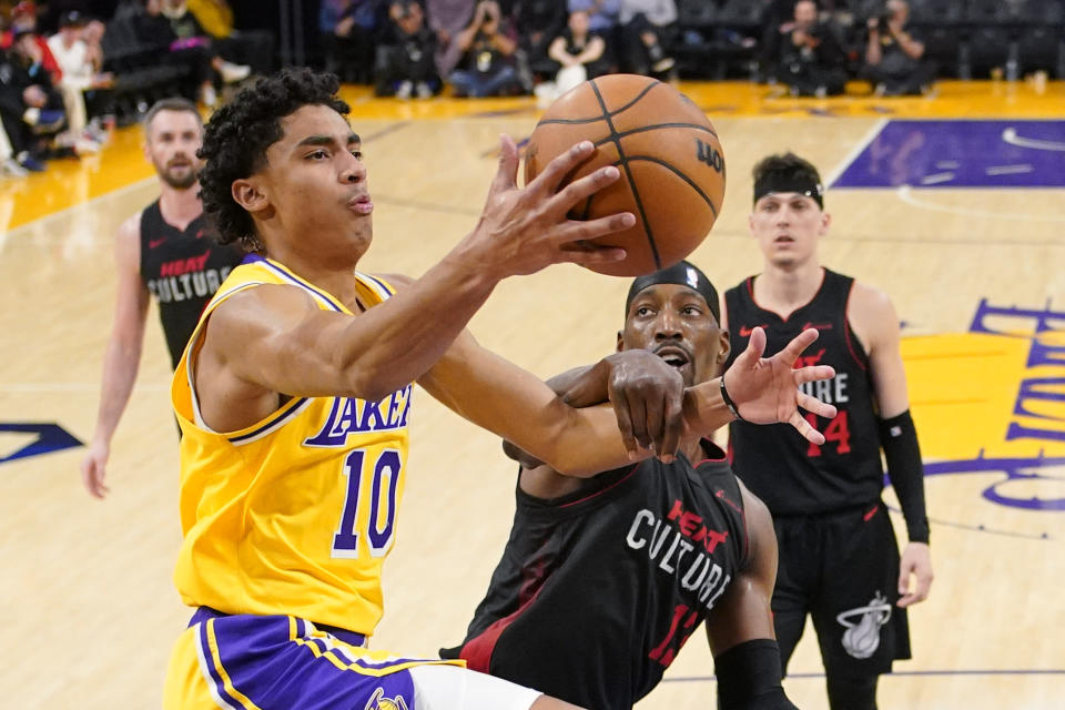 Los Angeles Lakers guard Max Christie, left, tries to shoot as Miami Heat center Bam Adebayo defends during the second half of an NBA basketball game Wednesday, Jan. 3, 2024, in Los Angeles. (AP Photo/Mark J. Terrill)