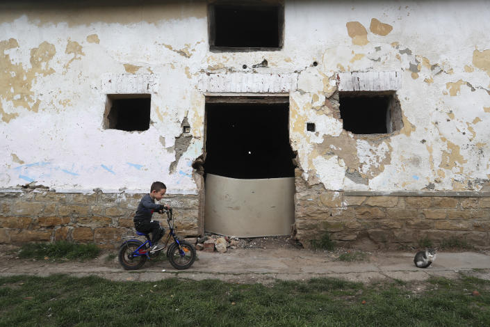 Milan Bastyur, a 4 year old Hungarian Roma child, rides a bike outside his family's home in Bodvaszilas, Hungary, Monday, April 12,2021. Many students from Hungary's Roma minority do not have access to computers or the internet and are struggling to keep up with online education during the pandemic. Surveys show that less than half of Roma families in Hungary have cable and mobile internet and 13% have no internet at all. (AP Photo/Laszlo Balogh)