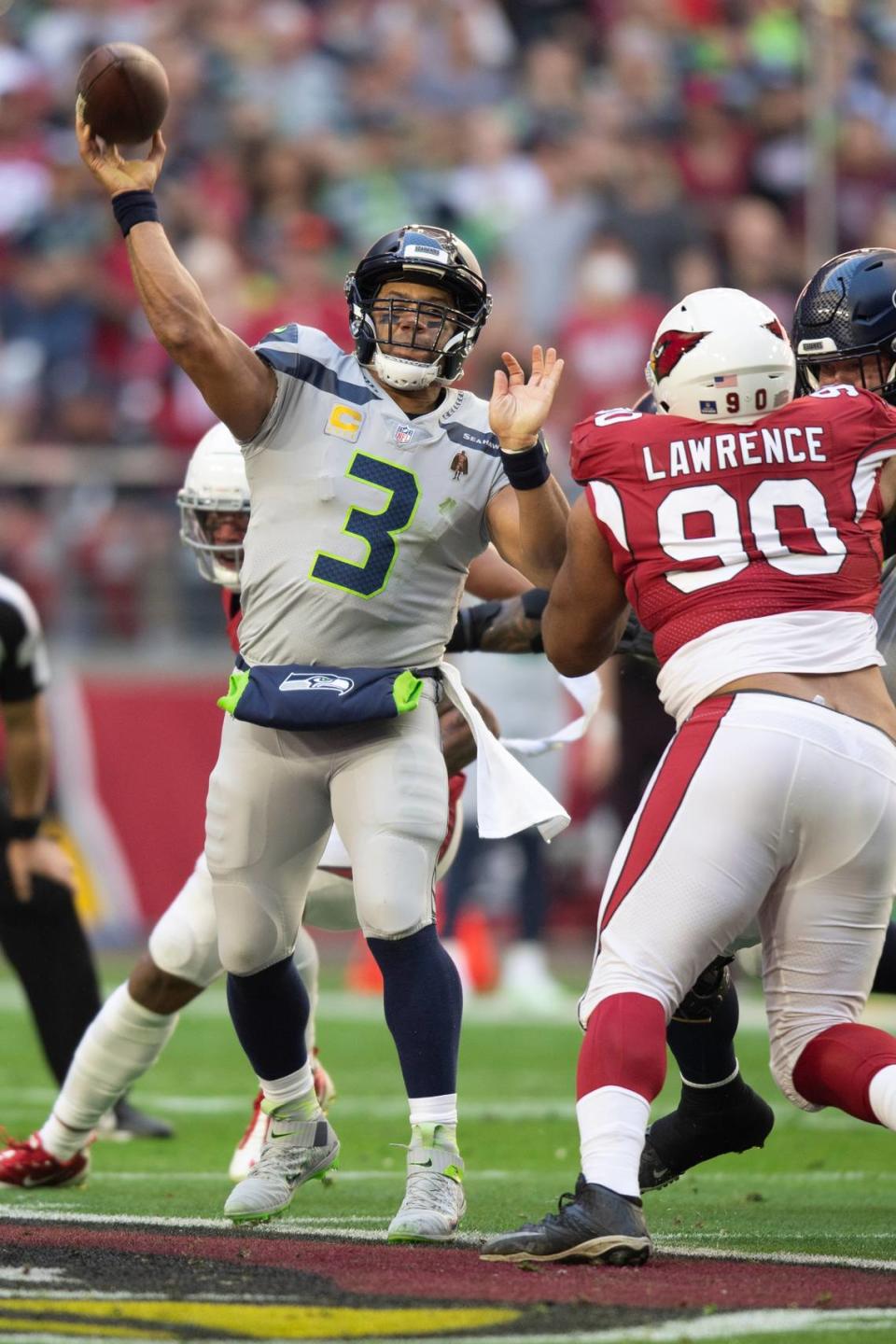 Seattle Seahawks quarterback Russell Wilson (3) passes while Arizona Cardinals defensive tackle Rashard Lawrence (90) rushes in the first half during an NFL Professional Football Game Sunday, Jan. 9, 2022, in Phoenix. (AP Photo/John McCoy)