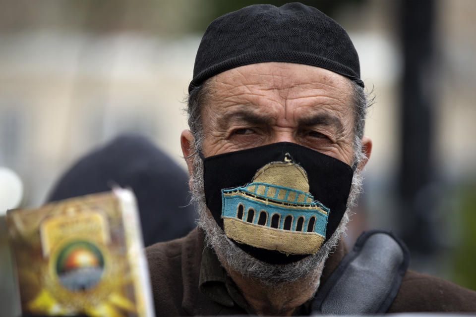 A Palestinian man wearing a face mask embroidered with an image of the Al-Aqsa Mosque takes part in a demonstration demanding protection from the coronavirus for Palestinians in Israeli jails, in the West Bank city of Ramallah, Sunday, Jan. 31, 2021. (AP Photo/Majdi Mohammed)