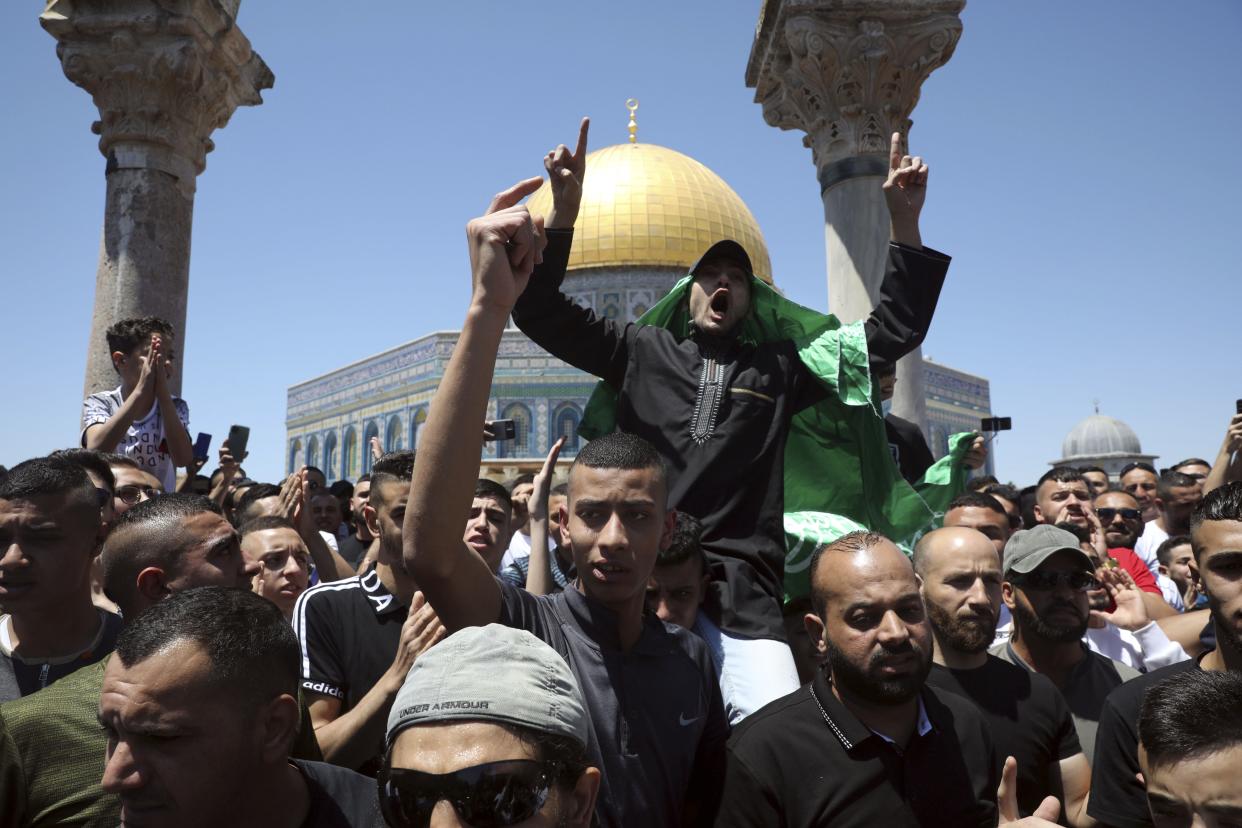 A Muslim worshiper wears a Hamas flag during a protest against Israeli airstrikes on the Gaza Strip following Friday prayers at the Dome of the Rock Mosque in the Al-Aqsa Mosque compound in the Old City of Jerusalem on Friday. 