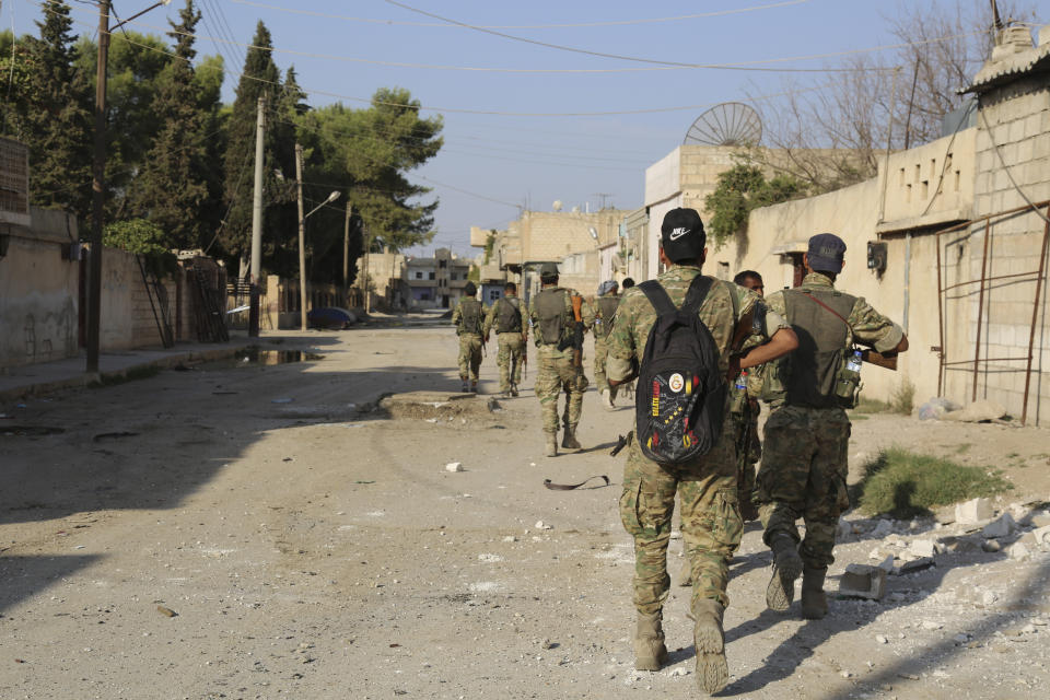 In this Saturday, Oct. 12, 2019 photo, Turkey-backed Syrian fighters enter Ras al-Yan, Syria.Turkey's military says it has captured a key Syrian border town Ras al-Ayn under heavy bombardment in its most significant gain as its offensive against Kurdish fighters presses into its fourth day. (AP Photo)