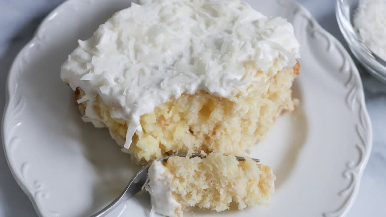 coconut poke cake slice on plate