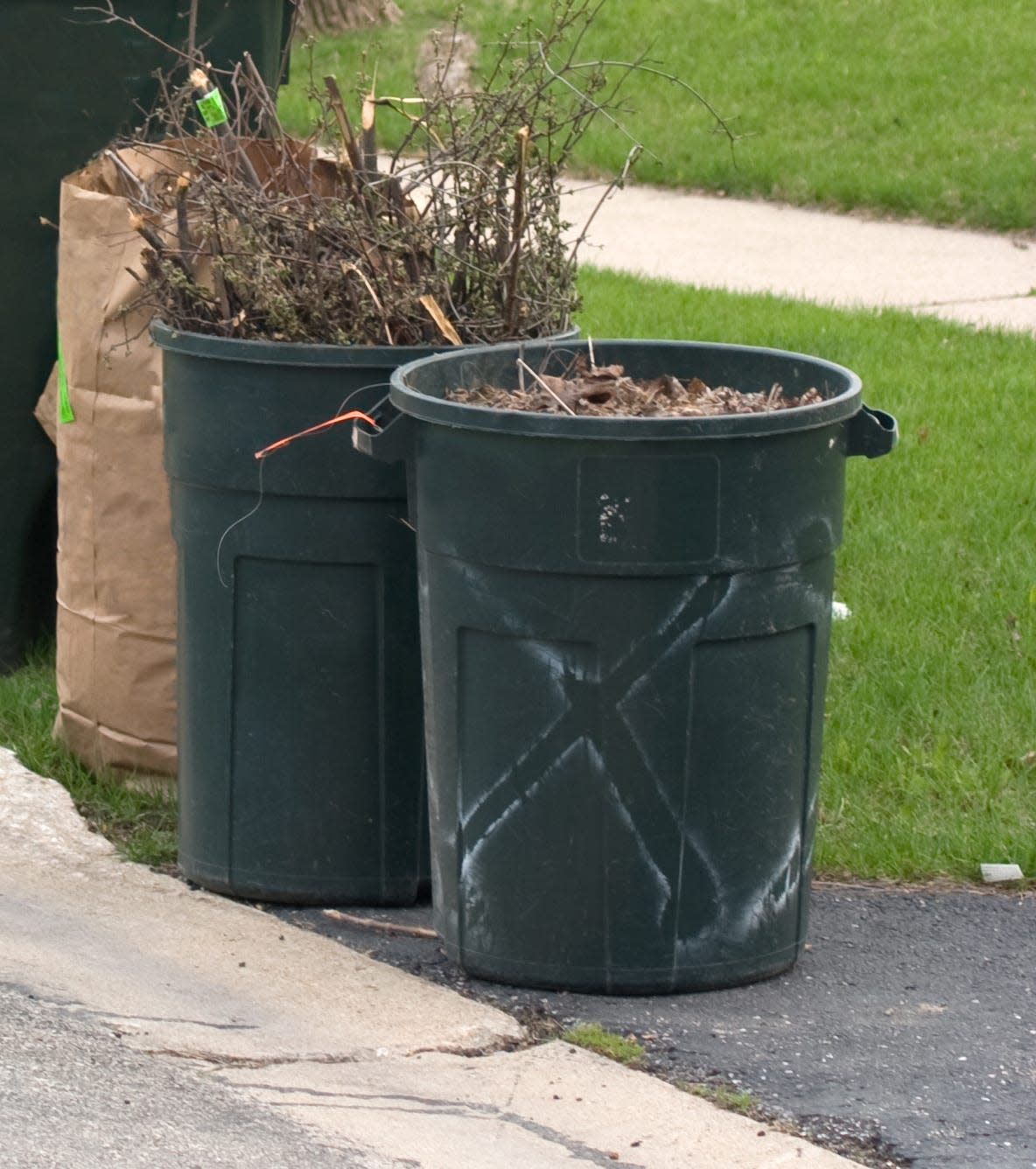 Trash and recycle containers sit at the curb awaiting pickup.