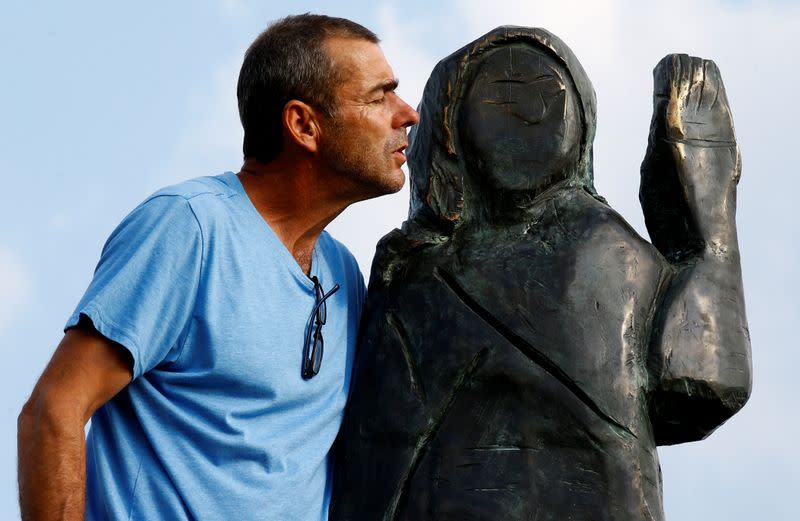 Ales Zupevc stands next to the new bronze statue of U.S. first lady Melania Trump in Rozno, near her hometown of Sevnica