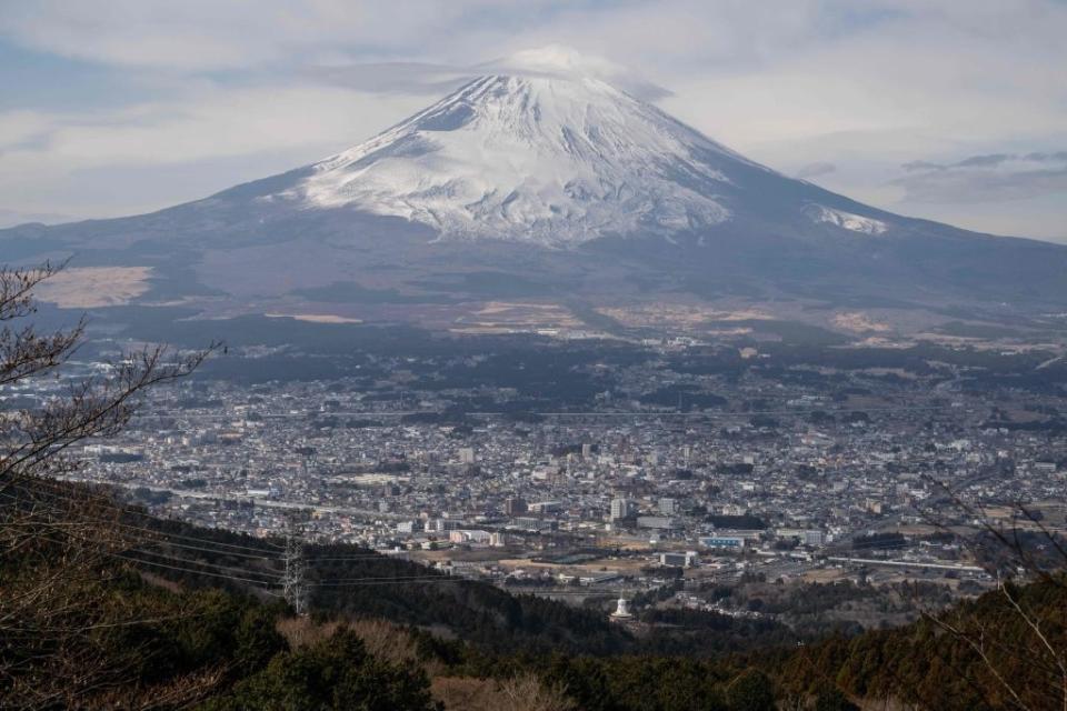 The photo is overlooking the city, which is dwarfed by the large mountain behind it