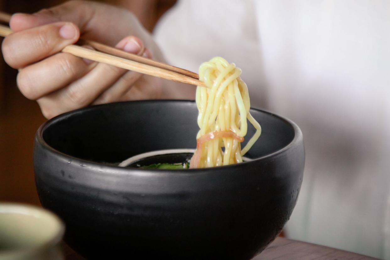 traditional Japanese Zaru Soba noodles with hand holding chopsticks