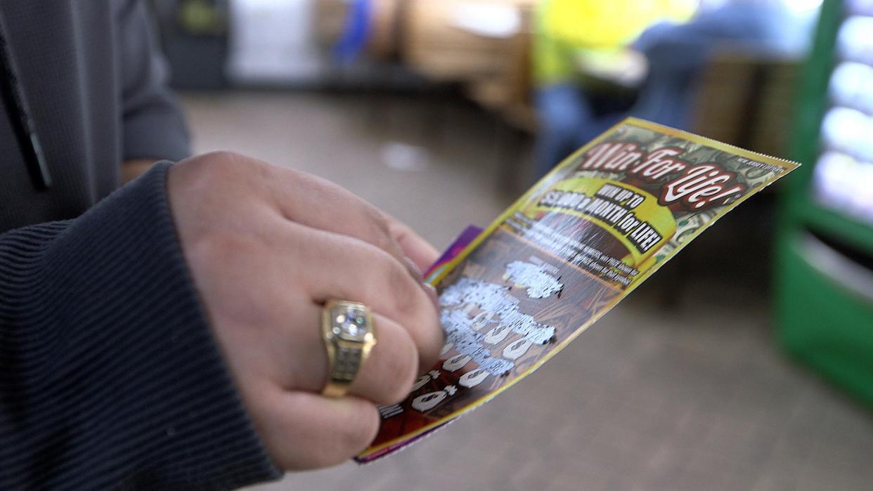 A woman plays a scratch-off ticket.