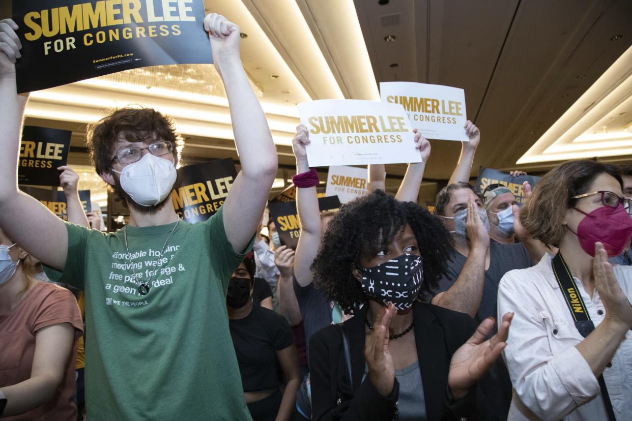 A crowd cheers in support of Summer Lee. Many people hold up signs reading: Summer Lee for Congress.