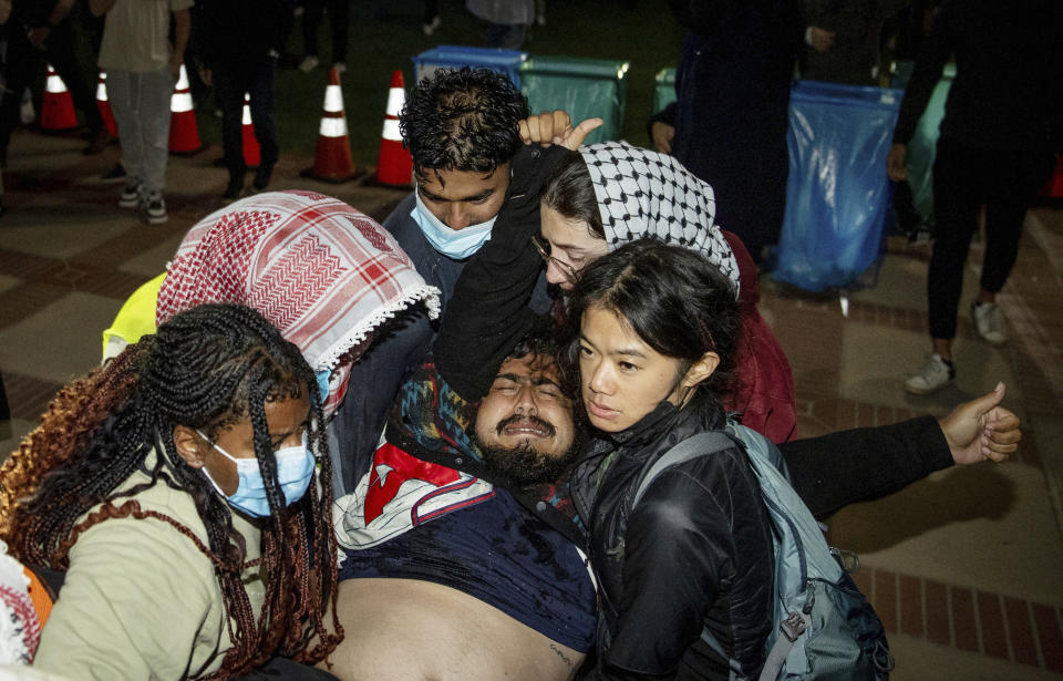 FILE - A person is carried away at a pro-Palestinian encampment at UCLA late Tuesday, April 30, 2024, in Los Angeles. Dueling groups of protesters clashed at the University of California, Los Angeles, grappling in fistfights and shoving, kicking and using sticks to beat one another. (AP Photo/Ethan Swope, File)