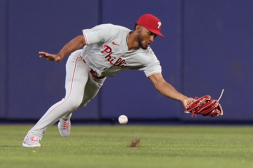 Philadelphia Phillies center fielder Johan Rojas is unable to catch a ball hit by Miami Marlins' Jake Burger for a single during the first inning of a baseball game, Saturday, May 11, 2024, in Miami. (AP Photo/Wilfredo Lee)