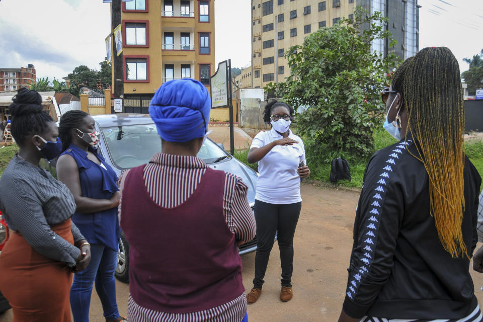 Rebecca Makyeli, center-right, spokeswoman for Uganda's new all-female ride-hailing service Diva Taxi, trains new drivers in self-defense skills in Kampala, Uganda Monday, Sept. 28, 2020. Uganda's latest ride-hailing service Diva Taxi has recruited over 70 drivers ranging from college students to mothers wishing to make good use of their secondhand cars, breaking the mold in the socially conservative country by hiring only female drivers. (AP Photo/Ronald Kabuubi)