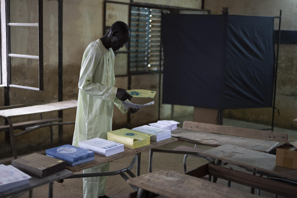 A man collects voting cards, that are set on a table, before casting his vote for legislative elections at a polling station in Dakar, Senegal, Sunday, July 31, 2022. The West African nation is holding legislative elections, a vital test for opposition parties trying to minimize ruling party influence before 2024 presidential elections amid worries President Macky Sall may seek a third term. (AP Photo/Leo Correa)