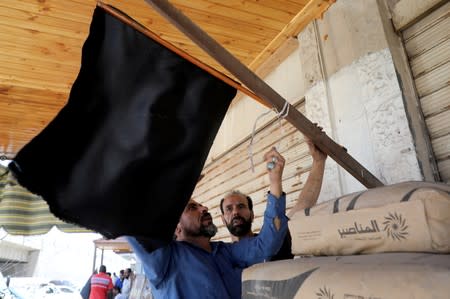 Shop owners put a black flag in front of their closed shop during a strike called by local activists against U.S. President Donald Trump's "Deal of the Century" at Al-Baqaa Palestinian refugee camp, near Amman