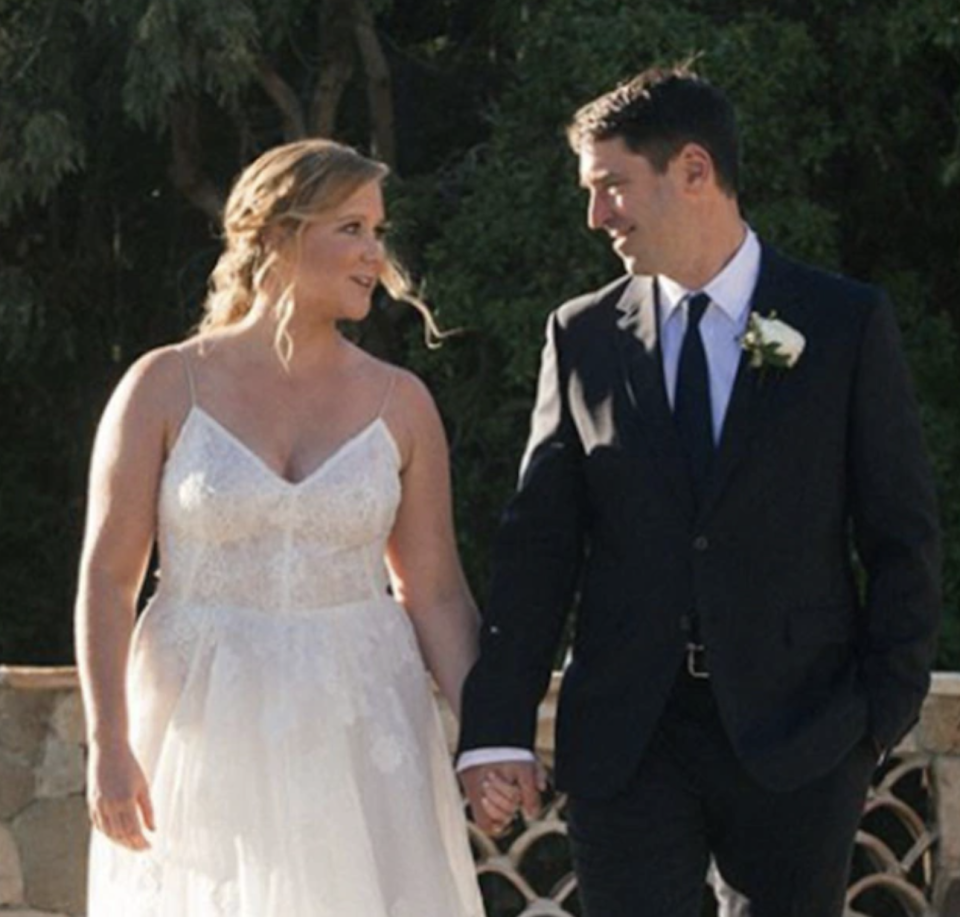 Chris Fischer and Amy Schumer at their wedding holding hands