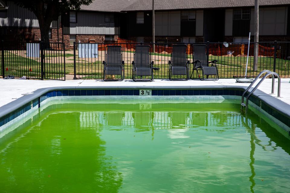 The pool at the Foxcroft Apartments, 6810 NW 16, sits empty on a hot August afternoon. The water has turned green and wasps hovered throughout the pool.