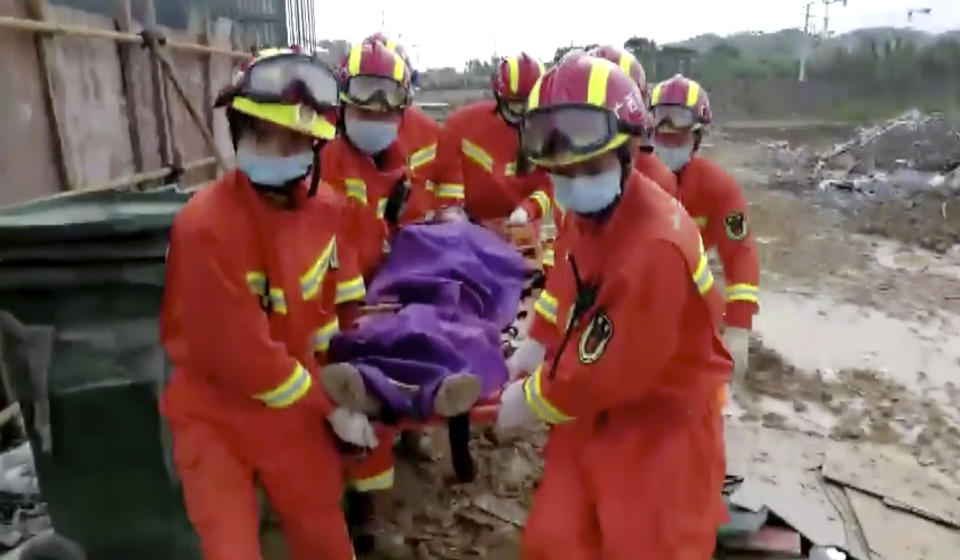 In this image from video, an injured is carried by rescuers to an ambulance from the site where a building collapsed in Baise City, Guangxi Zhuang Autonomous Region, south China, Monday, May 20, 2019. Framework surrounding a bar gave way on Monday, trapping or injuring almost 100 people. (CCTV via AP)