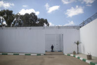 A police officer stands guard inside a prison during a ceremony that is part of a reconciliation program to rehabilitate and de-radicalize inmates on terrorism and extremism charges, in Sale, Morocco, Thursday, April 28, 2022. Since 2017, Morocco's prison authority has been offering “de-radicalization” training to former Islamic State fighters and others convicted of terrorism offenses. (AP Photo/Mosa'ab Elshamy)
