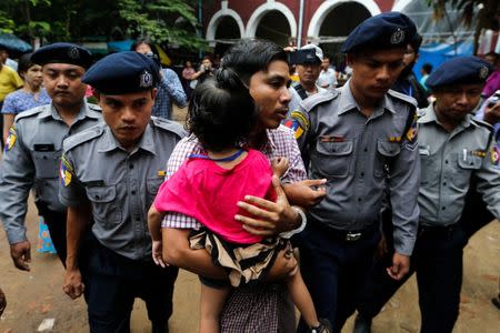 Detained Reuters journalist Kyaw Soe Oo carries his daughter Moe Thin Wai Zin while escorted by police to lunch break during a court hearing in Yangon, Myanmar June 18, 2018. REUTERS/Ann Wang