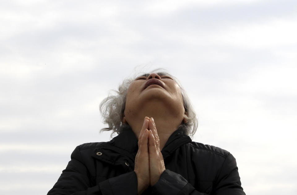 A weeping relative of a passenger aboard the sunken Sewol ferry prays as she awaits news on her missing loved one at a port in Jindo, South Korea, Tuesday, April 22, 2014. As divers continue to search the interior of the sunken ferry, the number of confirmed deaths has risen, with about 220 other people still missing. (AP Photo/Ahn Young-joon)