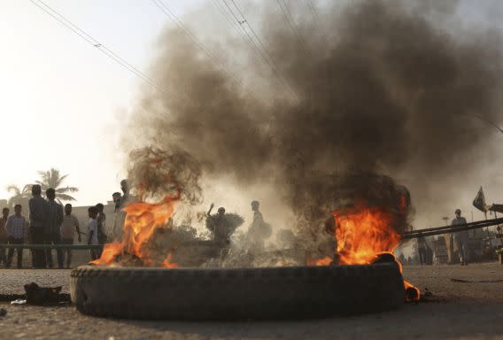 Protesters burn tyres in Karachi on Thursday (AP)