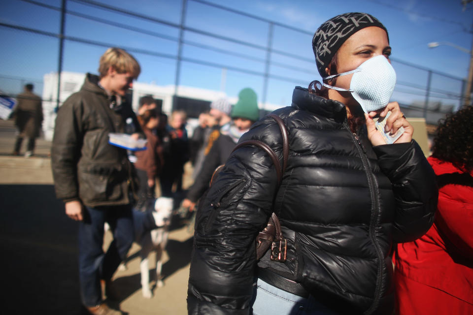 Rockaway resident Saajida O'Quinn wears a protective mask as she prepares to vote in a makeshift tent set up as a polling place at Scholars' Academy, PS 180, in the Rockaway neighborhood on November 6, 2012 in the Queens borough of New York City. The Rockaway section of Queens was one of the hardest hit areas and O'Quinn's home was damaged in Superstorm Sandy. Many voters in New York and New Jersey are voting at alternate locations in the presidential election due to disruption from the storm. (Photo by Mario Tama/Getty Images)