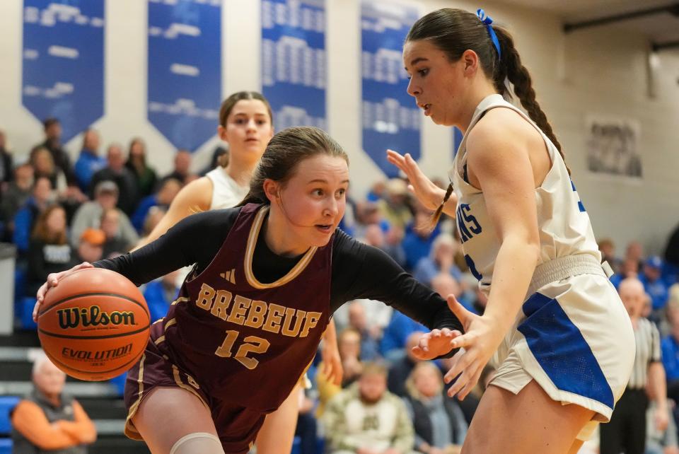 Brebeuf Jesuit's Audra Kendall (12) rushes past Bishop Chatard Trojans center Anna Caskey (44) on Tuesday, Jan. 30, 2024, during the game at Bishop Chatard High School in Indianapolis.