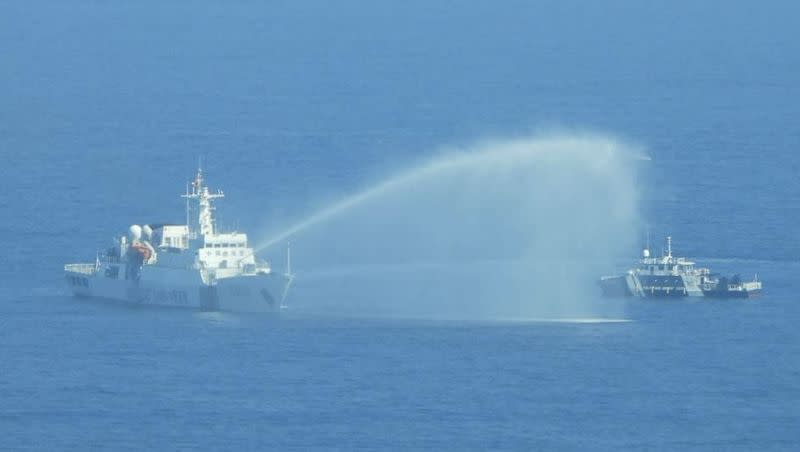 In this photo provided by the Philippine Coast Guard, a Chinese Coast Guard ship, left, uses its water cannons on a Philippine Bureau of Fisheries and Aquatic Resources vessel as it approaches Scarborough Shoal in the disputed South China Sea on Saturday, Dec. 9, 2023. The Philippines and its treaty ally, the United States, separately condemned a high-seas assault Saturday by the Chinese coast guard and suspected militia ships that repeatedly blasted water cannons to block three Philippine fisheries vessels.