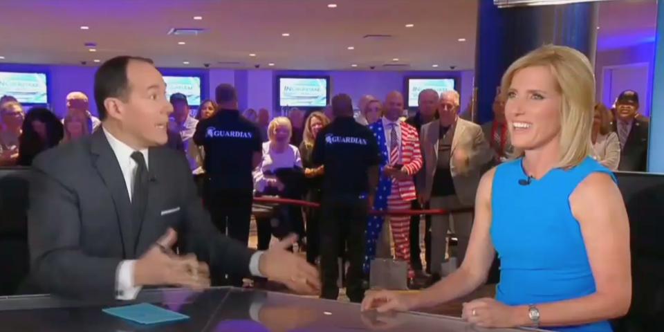 A screenshot of Raymond Arroyo and Laura Ingraham, with an audience in the background, talking animatedly on Fox News