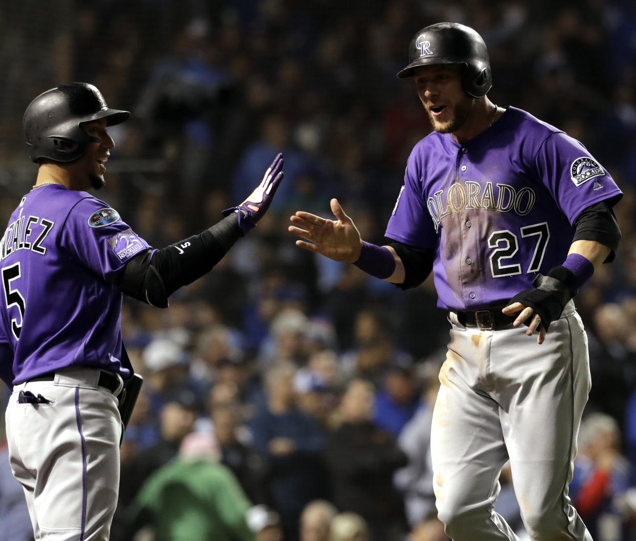 Trevor Story, right, celebrates with Carlos Gonzalez after scoring on a one-run single by Tony Wolters during the 13th inning of the National League wild-card playoff baseball game against the Chicago Cubs. (AP Photo)