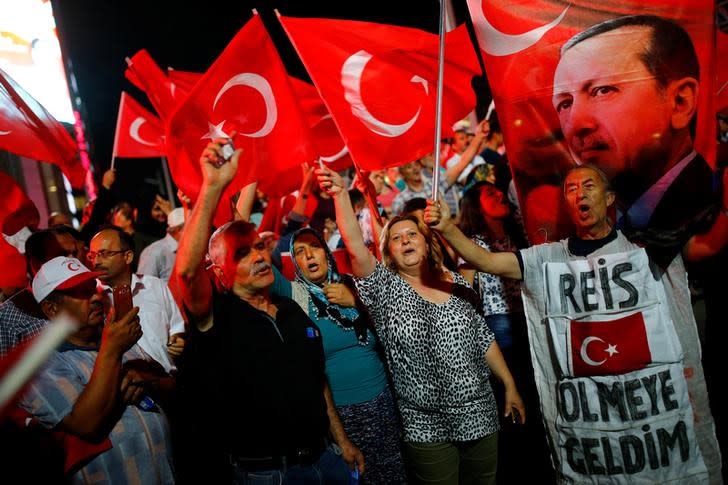 People shout slogans and wave Turkish national flags as they have gathered in solidarity night after night since the July 15 coup attempt in central Ankara, Turkey, July 27, 2016. The banner on the right reads 