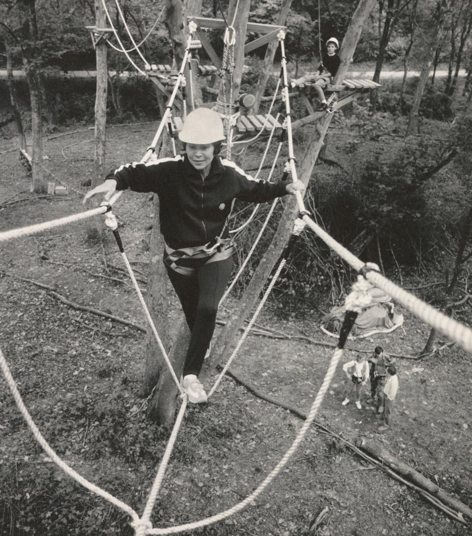 Maria Ferguson of Logan, Ohio, walks a “Burma Bridge” at the Camp Garfield Outdoor Recreation Center in Hocking Hills. Fellow camper Charlotte Castle, and daughter of camp co-founder Chuck Castle, sits on a platform behind her waiting to cross.