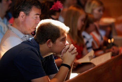 Parishioners pray during morning mass remembering victims of the theater shooting at Our Lady of Loreto Catholic Church in Aurora, Colorado. US President Barack Obama landed in Colorado on Sunday to meet relatives of those gunned down in the Aurora cinema massacre, after residents flocked to church services to remember the 12 dead