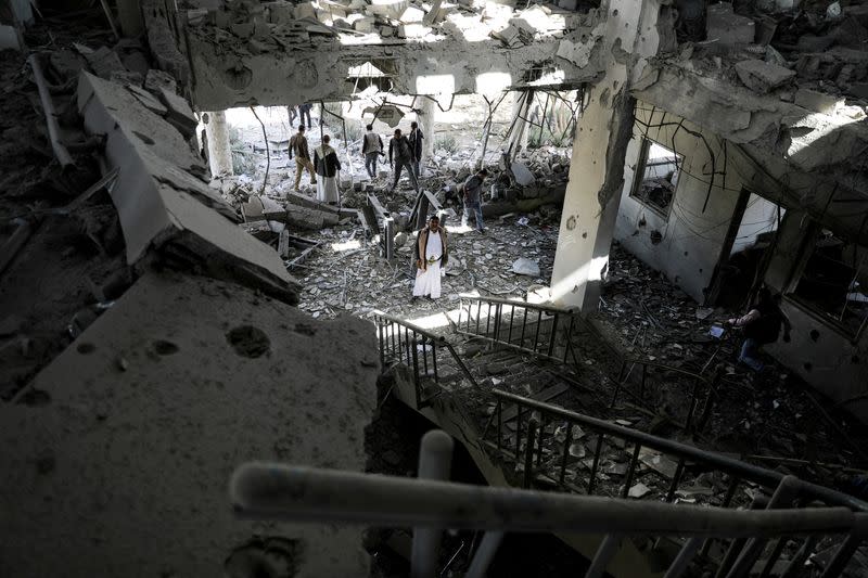 FILE PHOTO: Security guards and journalists inspect the site of a Saudi-led air strike on a telecommunication station, in Sanaa