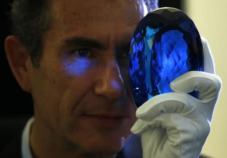 Philanthropist Maurice Ostro looks through his Ostro stone, the largest known blue topaz stone, for media at the Natural History Museum in London, Britain September 27, 2016. REUTERS/Peter Nicholls