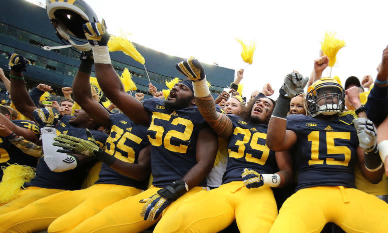 Michigan football players interacting with fans.
