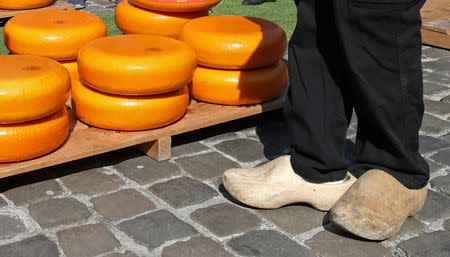 A seller stands next to Gouda wheels at the cheese market in Gouda, Netherlands April 18, 2019. REUTERS/Yves Herman