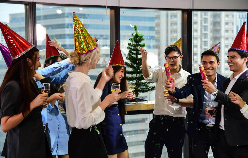 Business men and women with glasses of champagne celebrating Christmas and New Year for success in Business at the Office