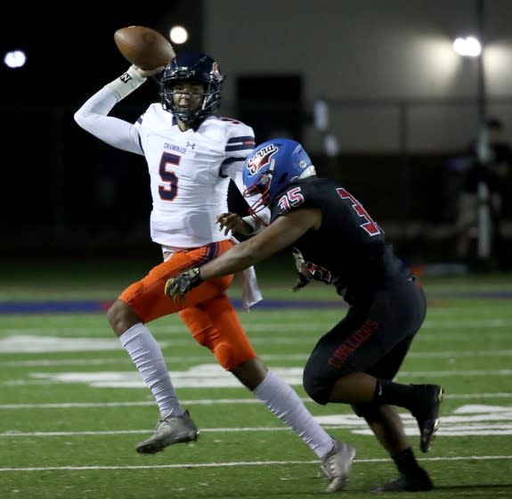 GARDENA, CALIF. - OCT. 8, 2021. Chaminade quarterback Indiana Wijay scrambles away from Serra linebacker Tanu Sosa on Friday night, Oct. 8, 2021. (Luis Sinco / Los Angeles Times)