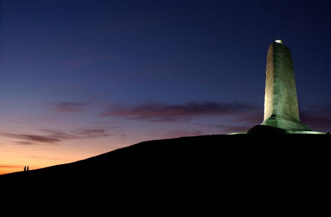 The sun begins to illuminate the morning sky over the monument at the Wright Brothers National Memorial at Kill Devil Hills.