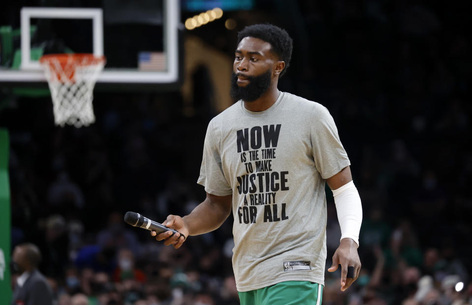 Boston Celtics guard Jaylen Brown (7) hands over a microphone after speaking to the fans on Martin Luther King, Jr. day before the start of an NBA basketball game against the New Orleans Pelicans, Monday, Jan. 17, 2022, in Boston. (AP Photo/Mary Schwalm)